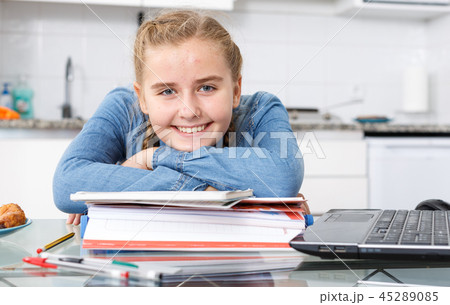 Happy girl sitting among notebooks 45289085