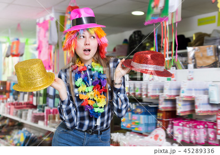 Cheerful woman choosing funny headdresses 45289336