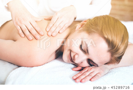 Adult masseuse makes relaxing massage shoulder zone to young woman Adult masseuse makes relaxing massage shoulder zone to young woman 45289716