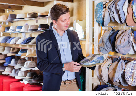 Portrait of male try on beret at the shopping mall Portrait of male try on beret at the shopping mall 45289718
