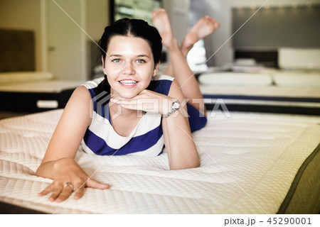 Customer girl is relaxing lying on new mattress before buying it Customer girl is relaxing lying on new mattress before buying it 45290001