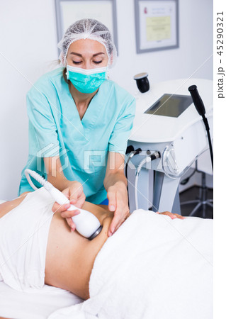 Beautician doing cryoliposuction 45290321