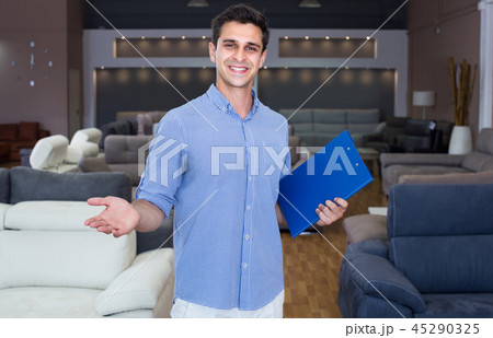 Salesman is showing prices on sofas Salesman is showing prices on sofas 45290325