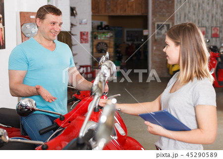 Couple is shopping and choosing new motobike Couple is shopping and choosing new motobike 45290589