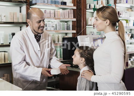 Mature pharmacist consulting customers Mature pharmacist consulting customers 45290595