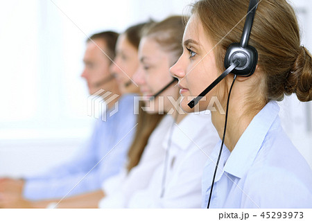 Call center operator in headset while consulting client. Telemarketing or phone sales Call center operator in headset while consulting client. Telemarketing or phone sales 45293973