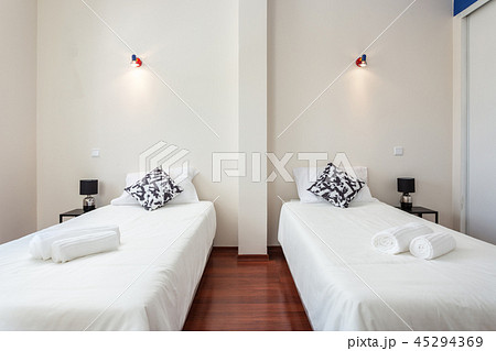 Modern bedroom with pillows and a bed for tourists. Frontally. 45294369
