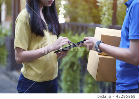 Asian young sign on tablet, delivery man bring box 45295869