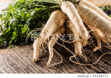 Close-up parsnip with parsley top on wooden board 45298111