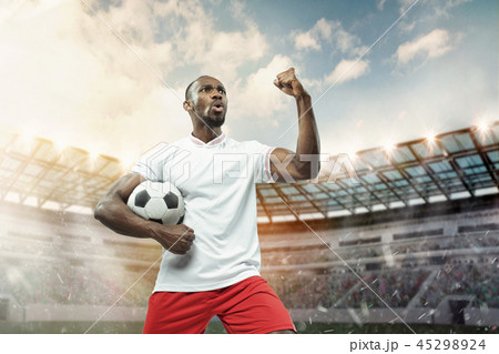 The football player in motion on the field of stadium The football player in motion on the field of stadium 45298924