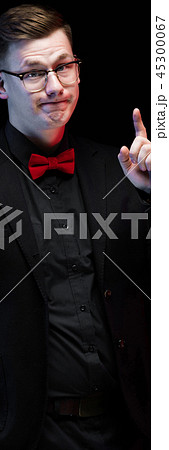Portrait of confident handsome elegant responsible businessman with idea gesture on black background 45300067