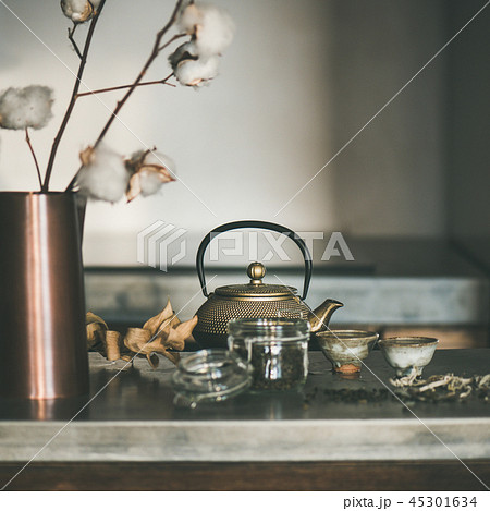 Golden teapot and cups on concrete counter, square crop Golden teapot and cups on concrete counter, square crop 45301634