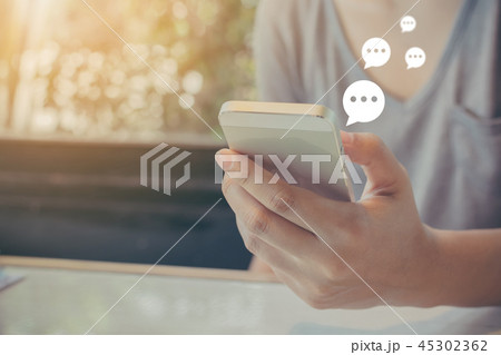 Hand of woman typing text on mobile smartphone 45302362