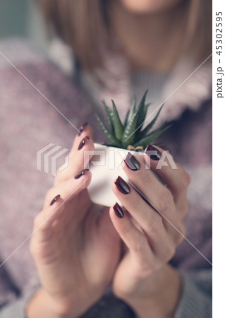 Girl holding a pot with a flower Girl holding a pot with a flower 45302595