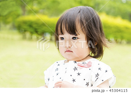 新緑の中で1人遊ぶ幼い女の子 45304115