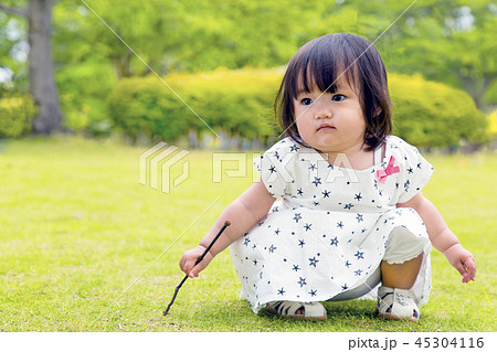 新緑の中で1人遊ぶ幼い女の子 45304116