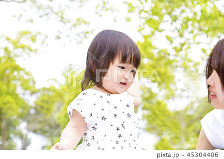 新緑の公園で幼い娘と遊ぶ若いお母さん。親子、家族、愛情、幸せイメージ 45304406