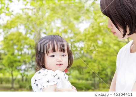 新緑の公園で幼い娘と遊ぶ若いお母さん。親子、家族、愛情、幸せイメージ 新緑の公園で幼い娘と遊ぶ若いお母さん。親子、家族、愛情、幸せイメージ 45304411