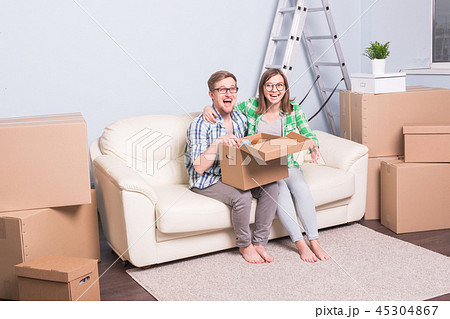 Family, new apartment, relocation and moving concept - a couple of young happy people opening their 45304867