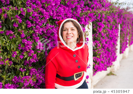 Holidays and people concept - smiling funny woman in christmas costume outdoors Holidays and people concept - smiling funny woman in christmas costume outdoors 45305947