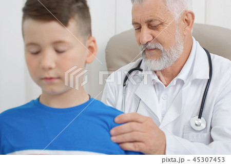 Professional doctor examining boy's back and spine. 45307453