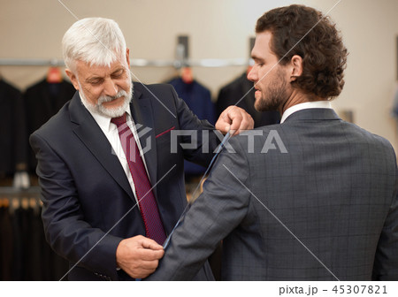 Attractive curly man coming to tailor for new costume. 45307821