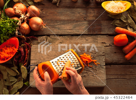 Woman hands rubs carrots on a grater 45322464