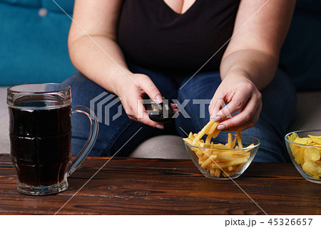 obese woman with tv remote, junk food and beer 45326657