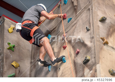 Young man practicing rock climbing Young man practicing rock climbing 45327696