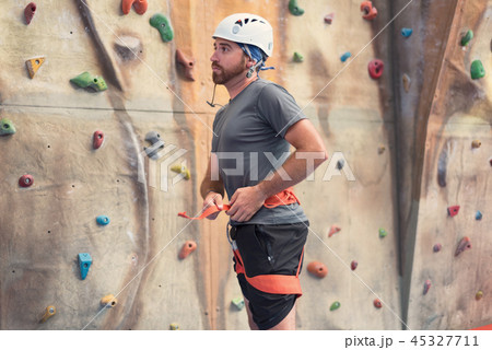 Man climber preparing to climb indoor wall. Man climber preparing to climb indoor wall. 45327711