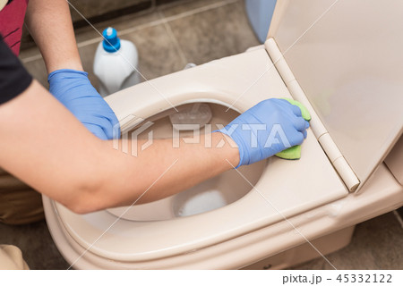 Man cleaning toilet bowl 45332122