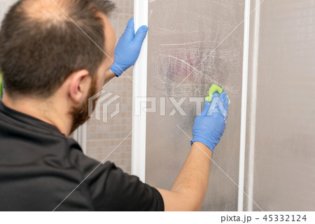 Man cleaning shower cabin. Man cleaning shower cabin. 45332124