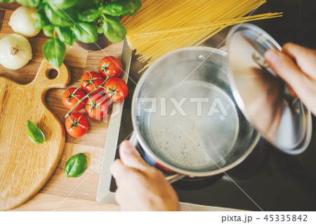 Man cooking pasta in boiling water 45335842