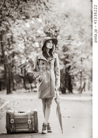 girl with umbrella and suitcase in the autumn park. 45336222