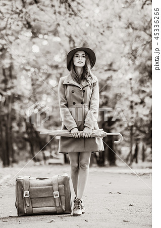 girl with umbrella and suitcase in the autumn park. girl with umbrella and suitcase in the autumn park. 45336266