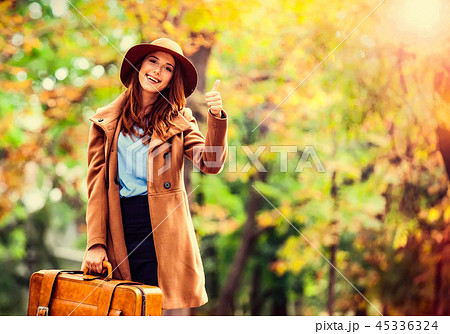 girl with suitcase in the autumn park. 45336324