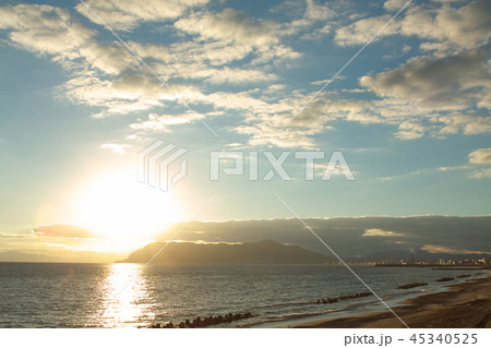 津軽海峡に沈む夕日と函館の街の写真素材