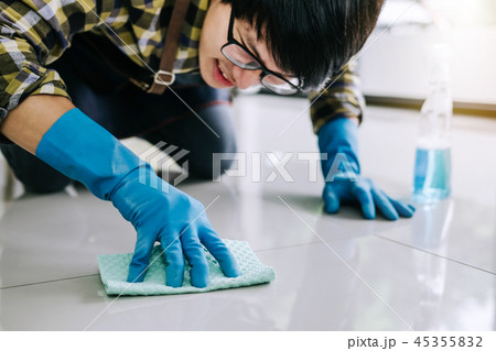 Husband housekeeping and cleaning concept, Happy young man in bl Husband housekeeping and cleaning concept, Happy young man in bl 45355832