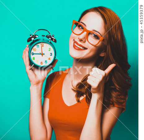 girl with alarm clock on blue background. 45359379