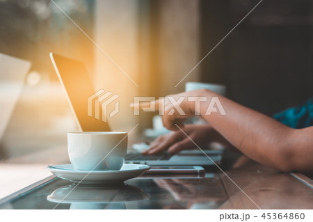Hands typing on laptop in coffee shop 45364860