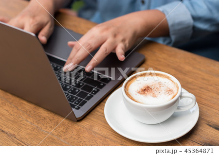 Hands typing on laptop in coffee shop Hands typing on laptop in coffee shop 45364871