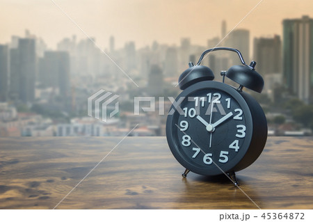 Black alarm clock on wooden table Black alarm clock on wooden table 45364872