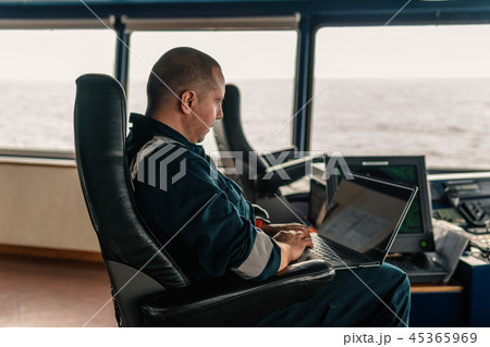 Marine navigational officer is using laptop or notebook at sea Marine navigational officer is using laptop or notebook at sea 45365969