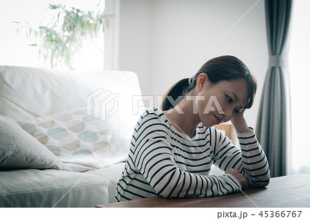 部屋で落ち込む30代女性 ストレス 日本人の写真素材