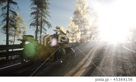 sportbike on tre road in forest with sun beams 45369156