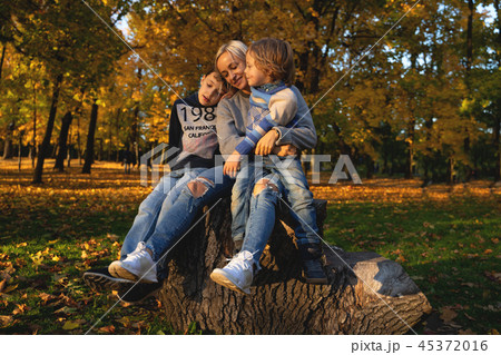 Smiling young family into leaves on an autumns day Smiling young family into leaves on an autumns day 45372016