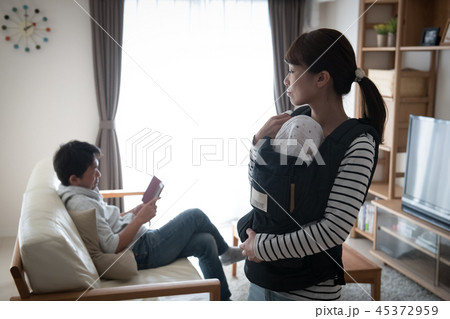 育児をしない夫と赤ちゃんを抱く不満げな妻 育児をしない夫と赤ちゃんを抱く不満げな妻 45372959