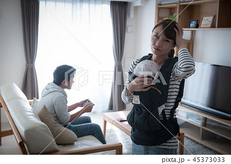 育児をしない夫にイライラする赤ちゃんを抱いた妻 45373033