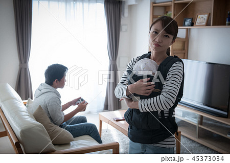 育児をしない夫にイライラする赤ちゃんを抱いた妻 45373034
