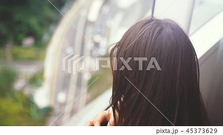 Young brunette woman looking through the window. urban city view with buildings and roads. Young brunette woman looking through the window. urban city view with buildings and roads. 45373629